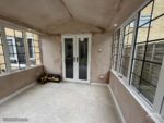 Inside conservatory with plastered ceiling and walls