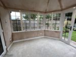 Inside conservatory with plastered ceiling and walls